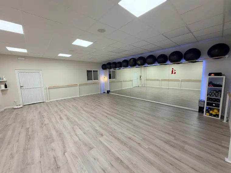 Sala de Aria con la pared de espejos, las barras de madera y los fitballs